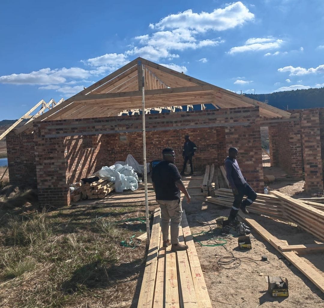 Roof trusses going up on a brick house